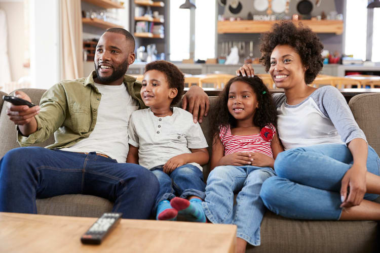 Family of four watching a movie together at home