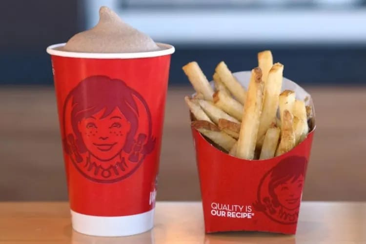 A Wendy's chocolate Frosty next to fries