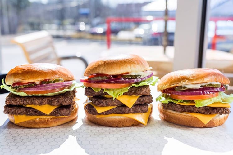 Three burgers lined up in a row, from Wendy’s, a restaurant open on Christmas Day