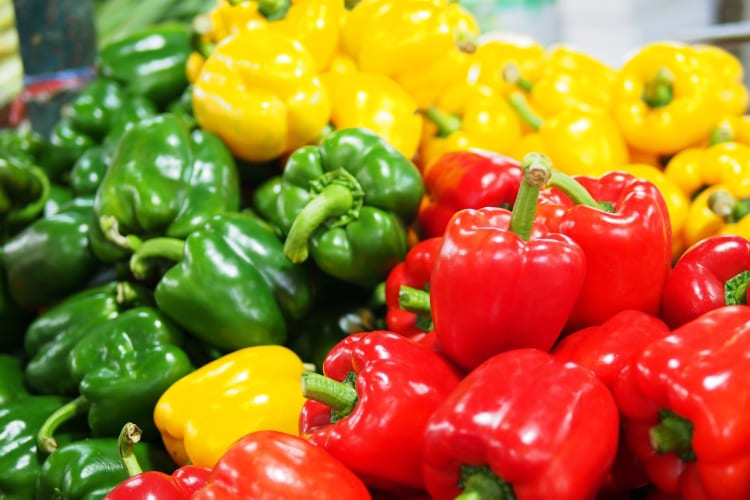 An abundance of green, yellow and red bell peppers.