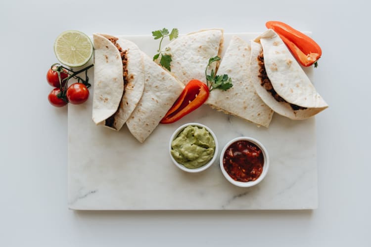 Tortillas, peppers and other accompaniments for vegetarian fajitas.