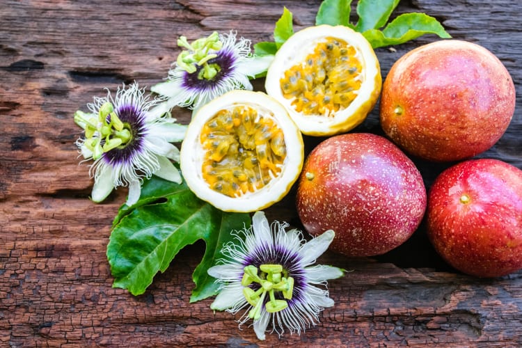 Passion fruit and flowers on a wooden background