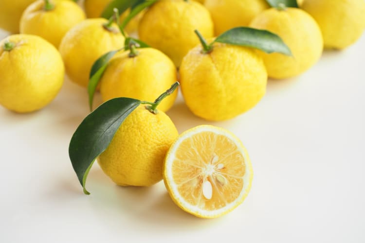 Whole and halved yuzu fruit
