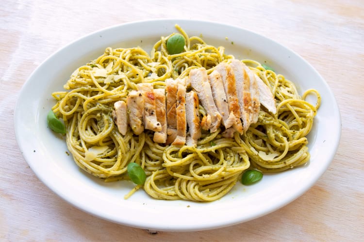 Linguini pasta dish with chicken and garnish on top