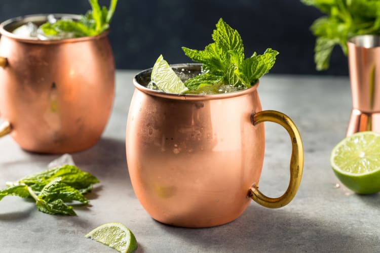 Copper cups with filled with mint and lime beverages