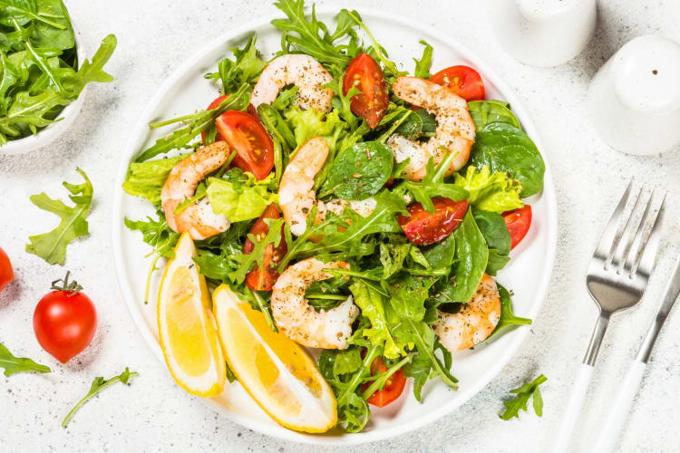 A salad with shrimp and lemon