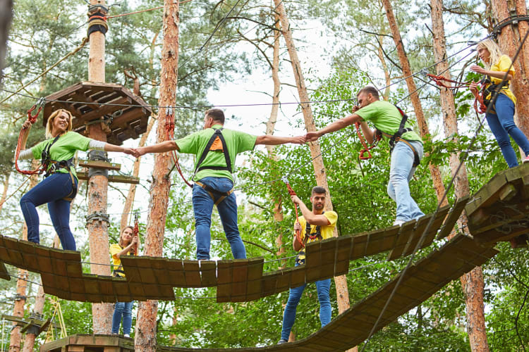 Five people making their way through an outdoor obstacle course