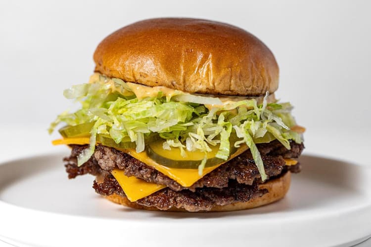 Eye-level view of a burger from Windmill Food Hall, a food hall in San Diego