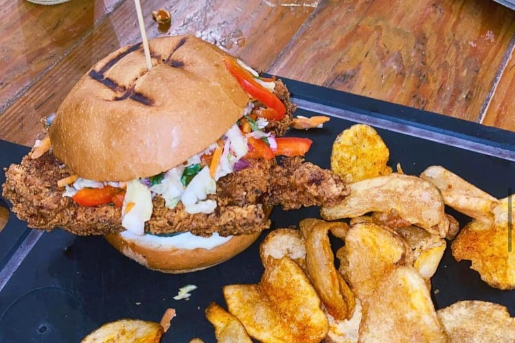 Crispy fried chicken sandwich and fries from Woodshed Smokehouse