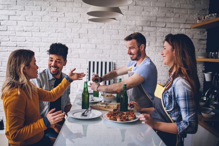 Four friends chatting and laughing over a meal at home