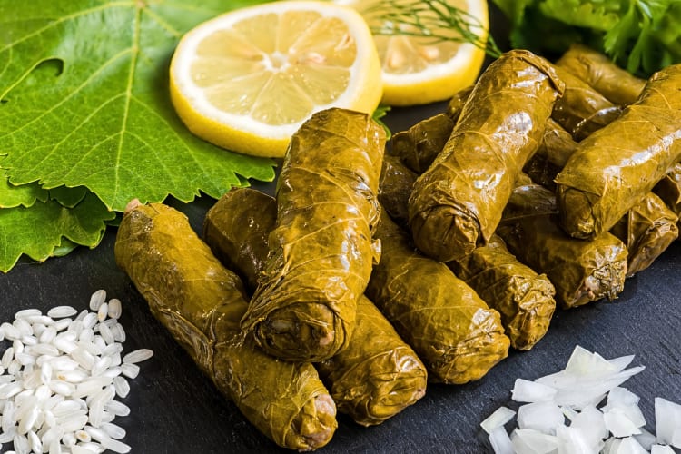 Yaprak sarma — stuffed Turkish leaves, surrounded by salt, lemon slices and herbs