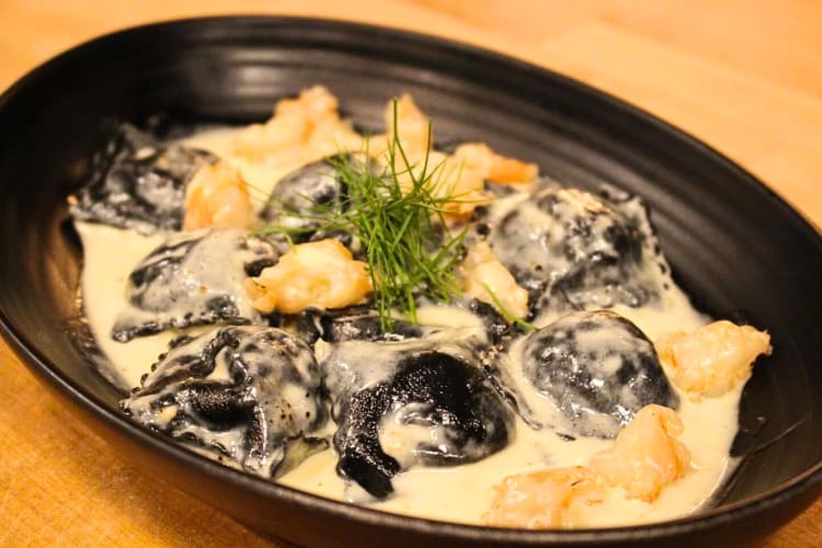Black ravioli topped with spiced poached shrimp from ÀLAVITA