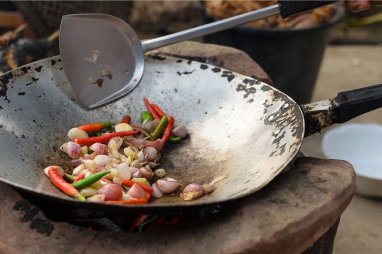 Anaheim peppers being friend in a pan with garlic