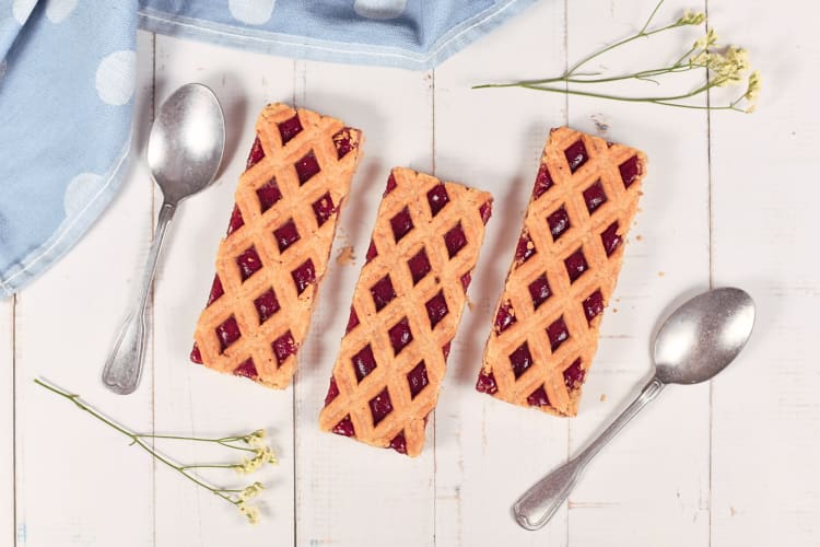 Aerial view of two spoons and three portions of Linzer torte, a delicious Austrian food
