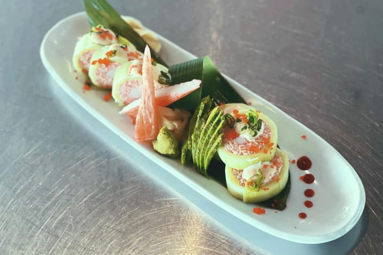 a cucumber-wrapped sushi roll on a table