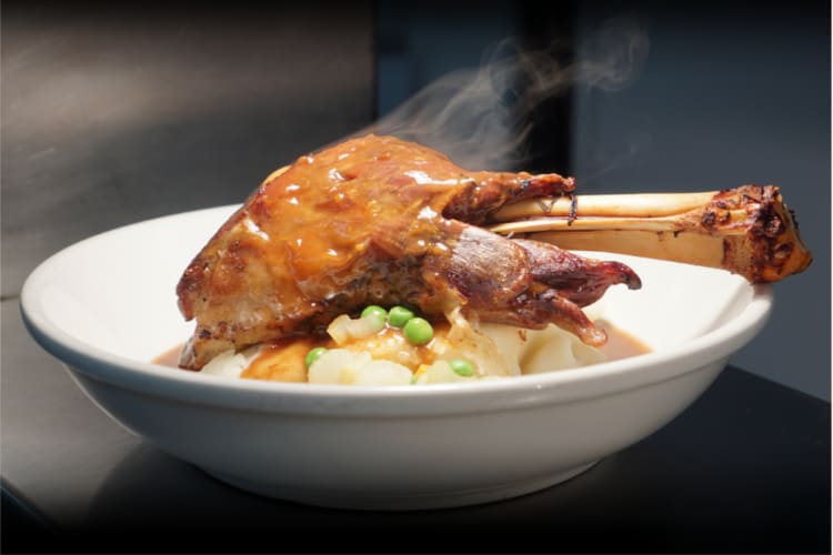 Lamb shank served with potatoes and vegetables