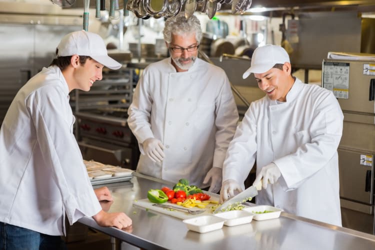 Three chefs cooking at a kitchen