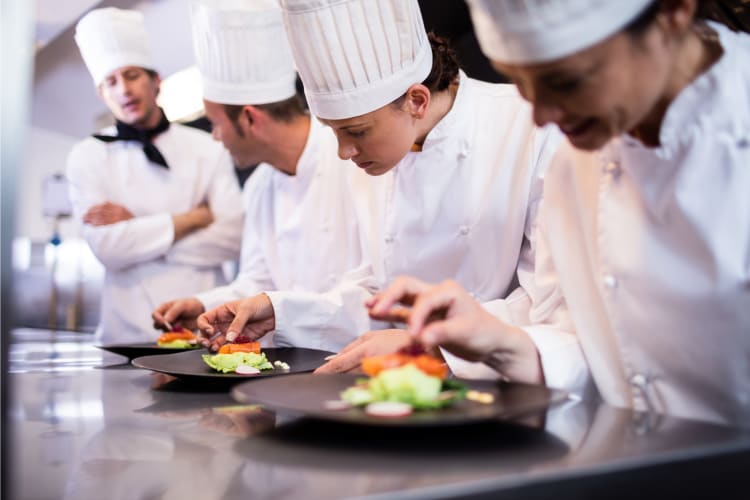 Chefs serving dishes at a class