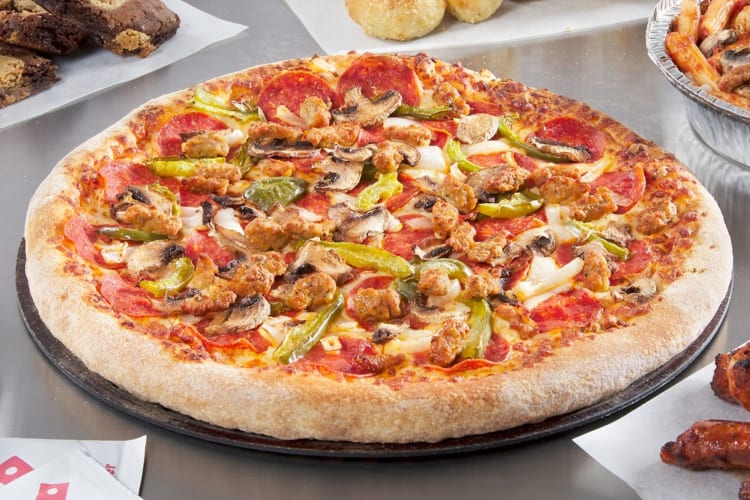A pizza with different meats and vegetables