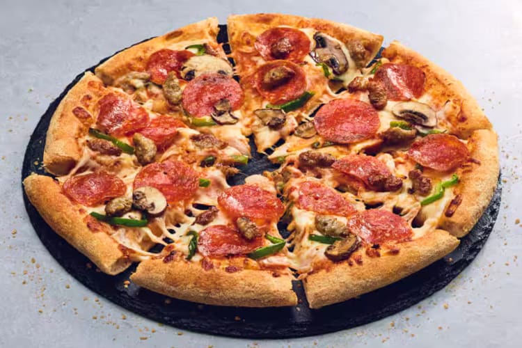 A pizza from Domino's with pepperoni, green peppers, onions and mushrooms
