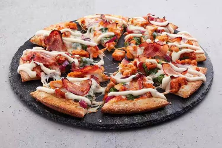 A pizza from Domino's with chicken, bacon, spinach and ranch dressing