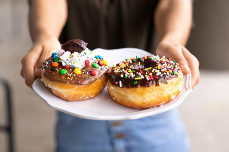 Two donuts topped with chocolates
