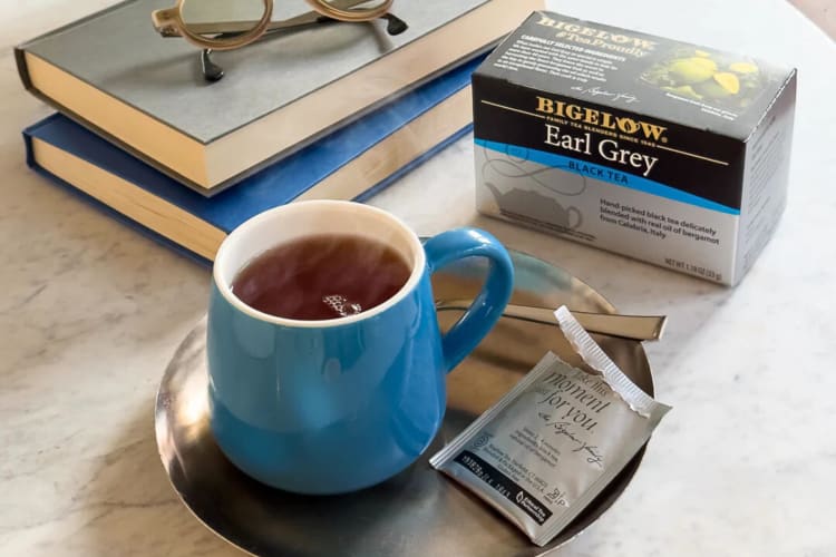 Books, glasses and a mug, box and sachet of Bigelow Earl Grey tea, one of the best Earl Grey teas