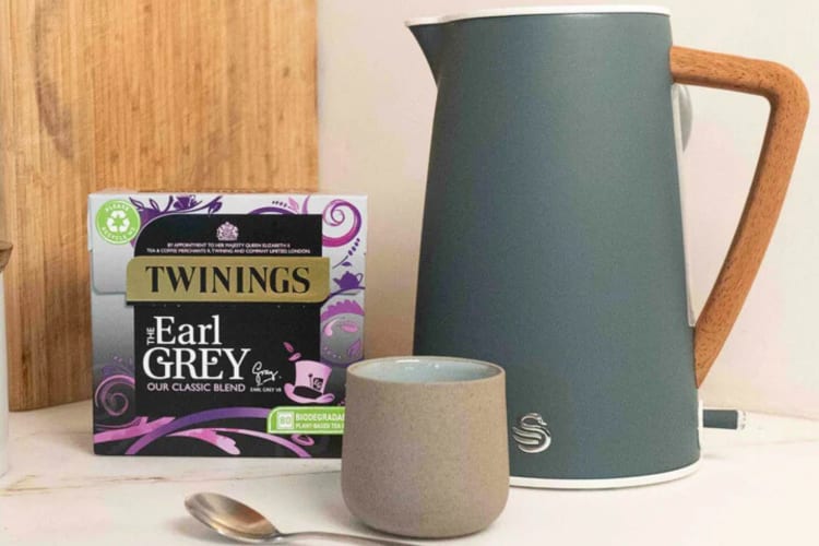 A kettle and mug next to a box of Twinings Earl Grey tea, one of the best Earl Grey teas