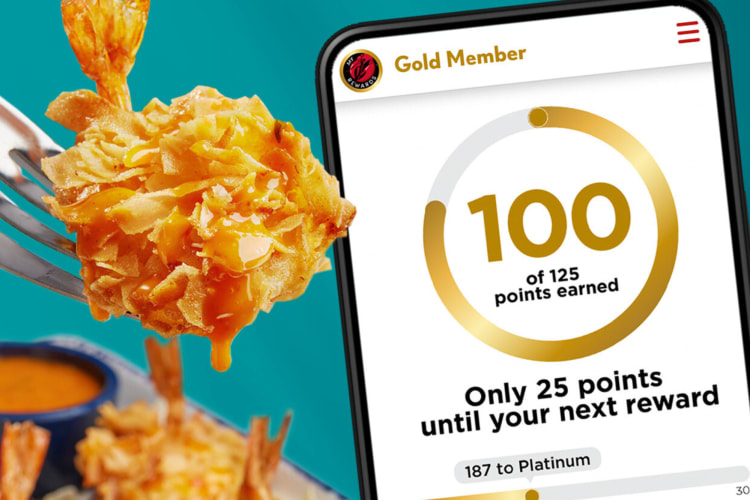 A phone displaying a page from the Red Lobster app, next to a piece of lobster