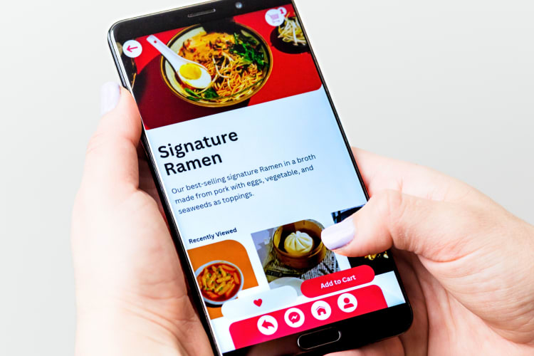 Hands holding a phone while ordering food on a food app