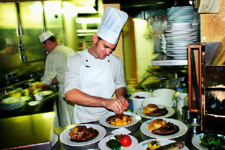 A chef cooking at one of the best French restaurants in Paris.