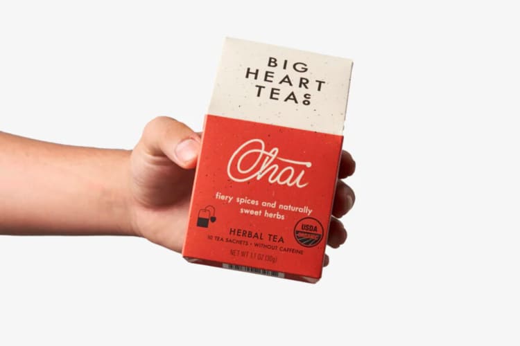 A hand holding a box of Big Heart Tea Co. Chai flavor, one of the best loose-leaf teas