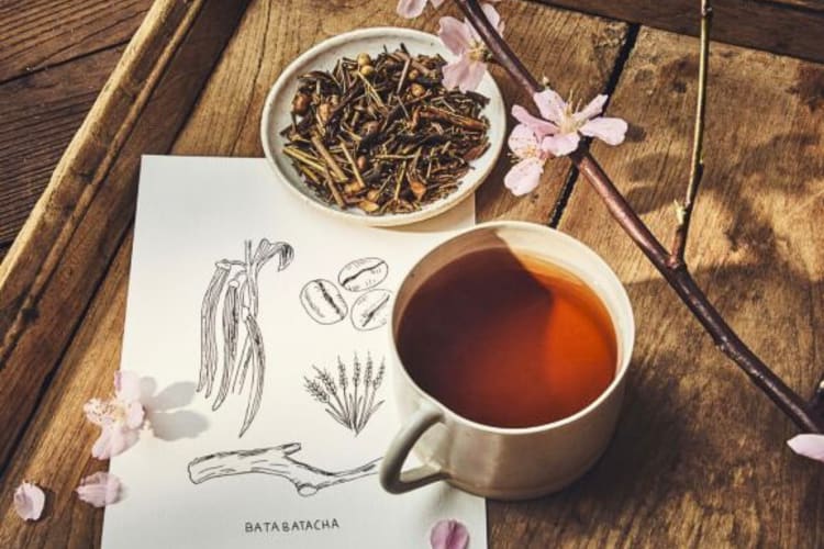 A mug of tea with a bowl of Palais des Thés tea leaves, one of the best loose-leaf teas