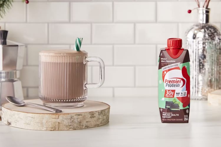 A carton of Winter Mint Chocolate Premier Protein next to a chocolate drink