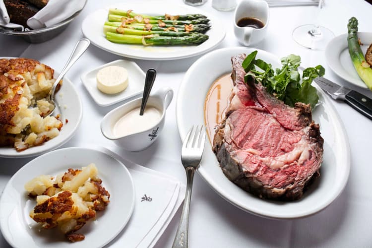 Plates of prime rib, asparagus and potato, from Gallaghers Steakhouse, one of the best restaurants in Times Square