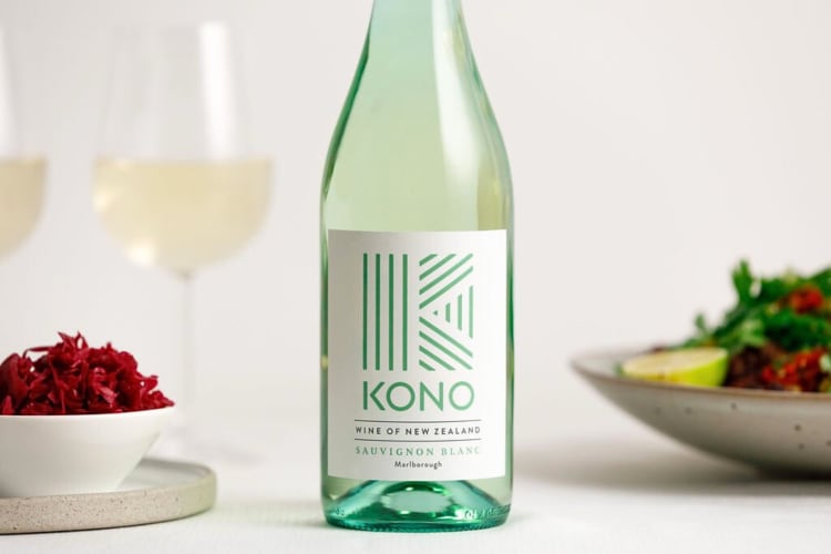 A bottle of Kono Sauvignon Blanc in between two salads