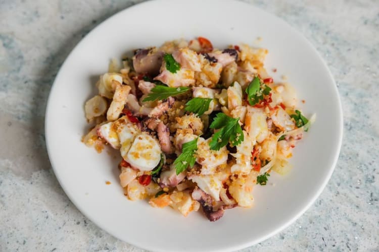 Seafood salad made with mussels, shrimp, lobster, onion, parsley, and panko