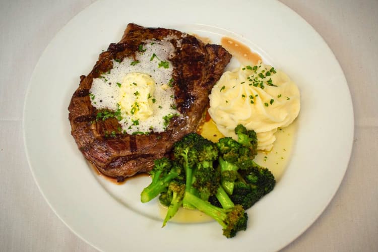 Prime rib with potatoes and broccoli.