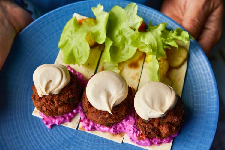Falafel served with tahini sauce, beet tzatziki and pickles