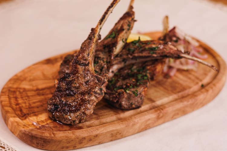 Lamb chops served on a wooden board
