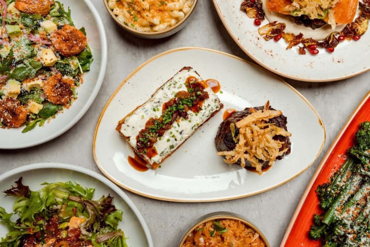 a spread of salads, steaks, and small plates