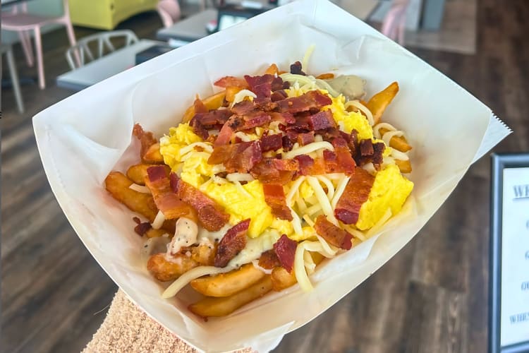 Breakfast poutine topped with cheese and bacon
