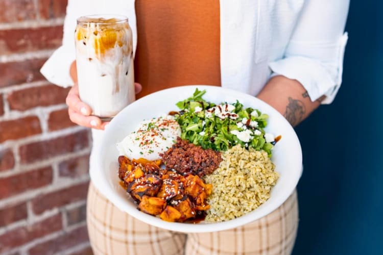 Bowl with poached eggs, wild rice, sweet potato, arugula and feta
