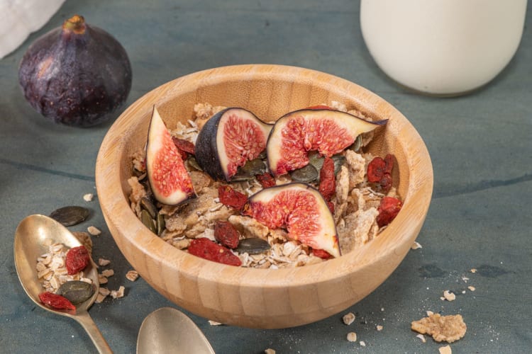 Bowl with granola, milk, fresh fig and dried berries