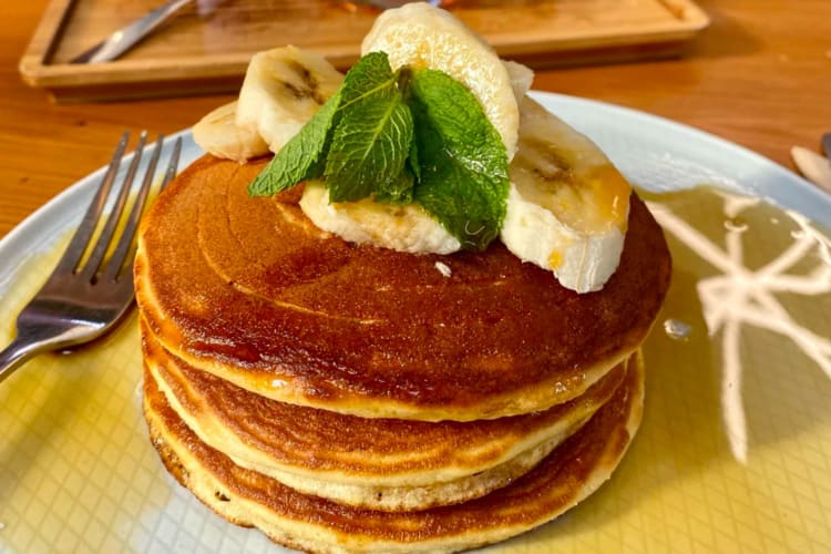 A stack of pancakes topped with sliced banana