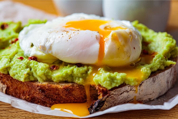 Smashed avocado on toast with poached eggs