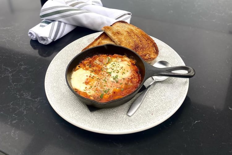 Sicilian baked eggs in a cast iron skillet with toast