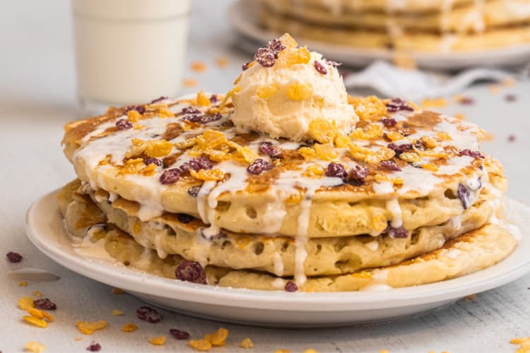 a stack of pancakes topped with cereal milk, sweet cream, mascarpone and powdered sugar