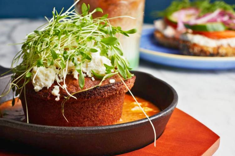 Street cornbread served in a skillet and topped with cotija cheese and micro cilantro