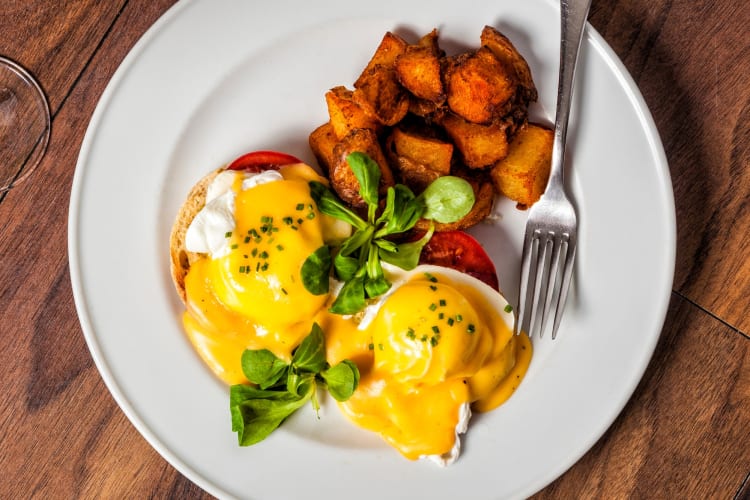 egg Benedict served with potatoes